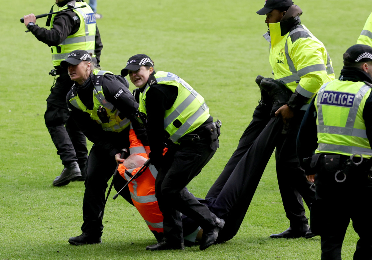 An injured steward is carried from the pitch 